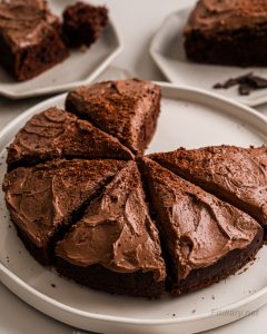 Sliced sugar-free chocolate cake on a platter showing moist texture and creamy chocolate frosting—ideal for weight loss or guilt-free indulgence