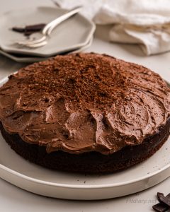 Healthy low calorie chocolate cake with rich frosting served on a white platter—perfect clean eating dessert or fitness-friendly treat