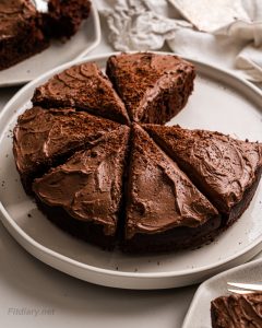 Sliced sugar-free chocolate cake on a platter showing moist texture and creamy chocolate frosting—ideal for weight loss or guilt-free indulgence