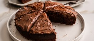 Sliced sugar-free chocolate cake on a platter showing moist texture and creamy chocolate frosting—ideal for weight loss or guilt-free indulgence