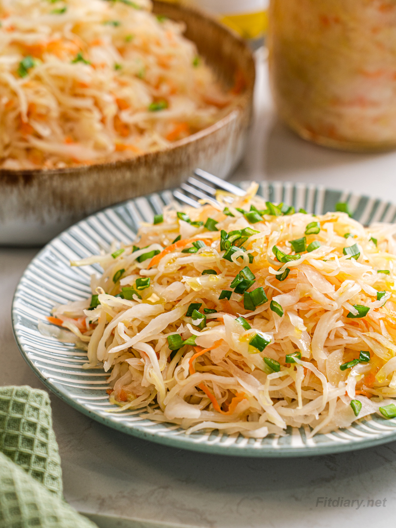 Served sauerkraut drizzled with olive oil and topped with chopped green onion as a healthy side dish
