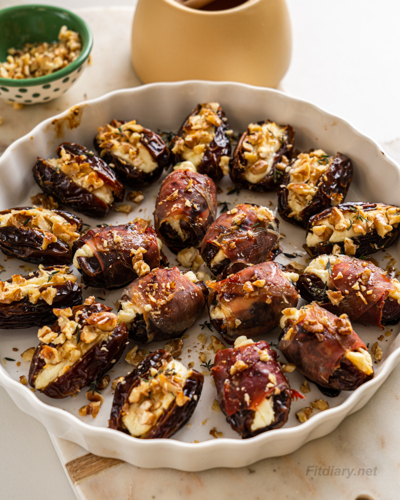Baked healthy cheese stuffed dates with walnuts and prosciutto in a baking dish