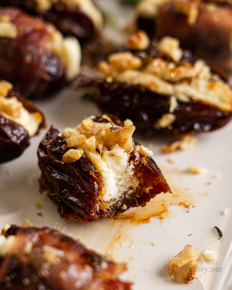 Close-up bite of a cheese stuffed date showing creamy ricotta feta filling inside