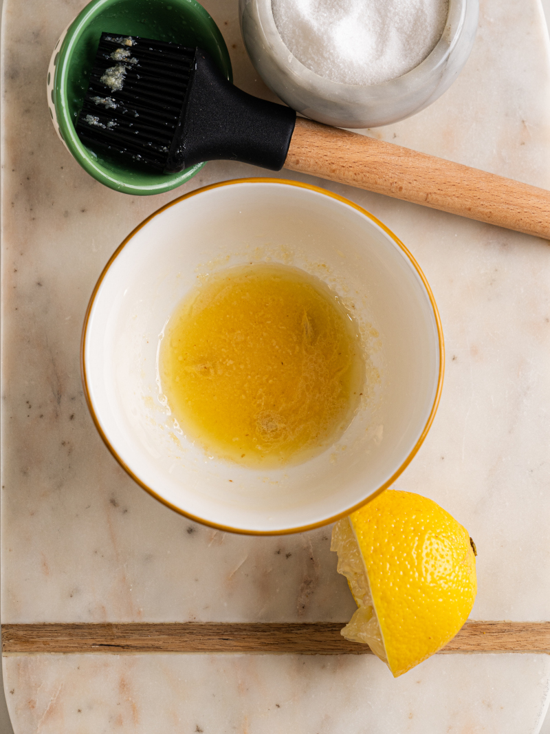 Small bowl with melted butter, lemon juice, and garlic powder mixed for air fryer salmon seasoning